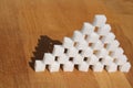 High sugar pyramid built of sugar cubes, concept of excess sugar intake, diabetic, close-up, copy space