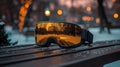 High tech augmented reality snow goggles displayed on a bench in a winter setting during sunset