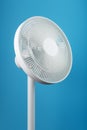 A high-tech white electric fan with a modern design for cooling the room on a blue background Royalty Free Stock Photo