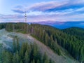 Tower Snezhanka in Rhodope mountains with fog, forest, sunbeams and sunny clouds Royalty Free Stock Photo