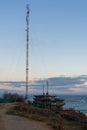 High tower. Telecommunications antenna on the high sea shore. Early autumn morning. Mainly cloudy