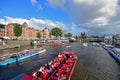 High traffic of passing boat canal Cruises filled with mass tourists on river canal with Amsterdam Central Station