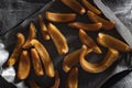 High view of freshly baked pumpkin slices on a tray, on a table with jute fabric. Recipe ingredients. Vegan diet context.