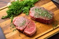 high view of herb rubbed steaks on wooden board