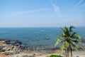 High view landscape with blue sky, sea, green palms at goa beach, coast line background and aircraft trail Royalty Free Stock Photo