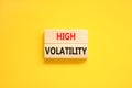 High volatility symbol. Concept words High volatility on beautiful wooden blocks. Beautiful yellow table yellow background.