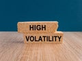 High volatility symbol. Concept words High volatility on brick bloks. Beautiful wooden table, blue background. Business high