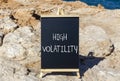 High volatility symbol. Concept words High volatility on beautiful black chalk blackboard. Chalkboard. Beautiful stone sea sky