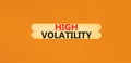 High volatility symbol. Concept words High volatility on beautiful wooden stick. Beautiful orange table orange background.