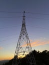 High voltage cable tower during sunset on a mountain