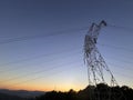 High voltage cable tower during sunset on a mountain Royalty Free Stock Photo