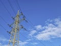 High voltage electric pole and power lines, high voltage electric transmission tower and blue cloudy sky Royalty Free Stock Photo