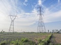 The high voltage electric pole stood tall and imposing in the middle of the field, Royalty Free Stock Photo