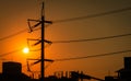 High voltage electric pole and transmission lines in the city. Electricity pylons at sunset. Power and energy. Energy conservation Royalty Free Stock Photo