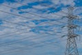 High voltage electric pylon and electrical wire against blue sky and clouds. Bottom view of electric pylon. High voltage grid Royalty Free Stock Photo
