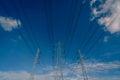 High voltage electric pylon and electrical wire against blue sky and white clouds. Looking up view of Electricity pylon. High Royalty Free Stock Photo