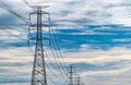 High voltage electric pylon and electrical wire with blue sky and white clouds. Tall electricity pole. Power and energy concept. Royalty Free Stock Photo