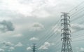 High voltage electric pylon and electrical wire with grey sky and white clouds. Electricity poles. Power and energy concept. High Royalty Free Stock Photo