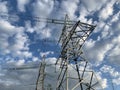 High voltage electric tower against the blue sky. High steel power pole, among the forest. High voltage electrical wires pass Royalty Free Stock Photo