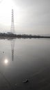 High-voltage electric tower reflected on the water Royalty Free Stock Photo