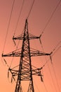 High voltage electric tower silhouette on bright orange background Royalty Free Stock Photo