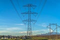 High voltage electric transmission tower against homes mountain and blue sky Royalty Free Stock Photo