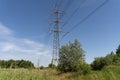 High-voltage electrical insulator electric line against the blue sky. In a natural landscape with grass and trees Royalty Free Stock Photo