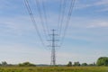 High-voltage electrical insulator electric line against the blue sky. In a natural landscape with grass and trees Royalty Free Stock Photo