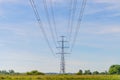 High-voltage electrical insulator electric line against the blue sky. In a natural landscape with grass and trees Royalty Free Stock Photo