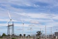 High voltage electrical power pylon substation with wind turbines renewable wind energy Royalty Free Stock Photo