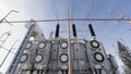 High voltage electrical substation on blue cloudy sky background. Action. Bottom view of a transformer near street