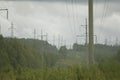 High voltage electrical transmission towers electricity pylons and power lines on green field Royalty Free Stock Photo