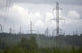 High voltage electrical transmission towers electricity pylons and power lines on green field Royalty Free Stock Photo