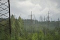 High voltage electrical transmission towers electricity pylons and power lines on green field