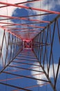 High Voltage Electricity Grid Pylon seen from below with blue sky