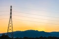 High voltage electricity post in countryside with mountain and sunset sky background Royalty Free Stock Photo