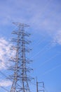 High voltage electricity pylon against blue sky background in low angle view and vertical frame Royalty Free Stock Photo