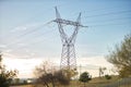 High voltage electricity tower placed in a park near the city during sunset. Concept energy, electricity, towers, high voltage Royalty Free Stock Photo