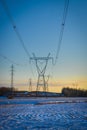 High voltage electricity transmission towers by aerial cables in winter Royalty Free Stock Photo