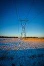 High voltage electricity transmission towers by aerial cables in winter Royalty Free Stock Photo