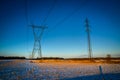 High voltage electricity transmission towers by aerial cables in winter Royalty Free Stock Photo