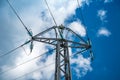 High-voltage insulated wires on glass insulators of power transmission towers against the background of blue sky and