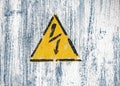 High voltage lightning sign in a yellow triangle on a painted wall