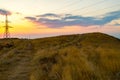 High voltage line surrounded by wheat fields at sunset Royalty Free Stock Photo