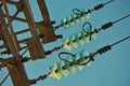 High voltage lines and a glass insulators. Closeup of high voltage lines with insulators and a minor part of a power pylon against Royalty Free Stock Photo