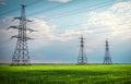 High voltage lines and power pylons in a flat and green agricultural landscape on a sunny day with clouds in the blue sky. Cloudy Royalty Free Stock Photo