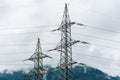 High voltage overhead power line, power pylon, steel lattice tower standing in the Alps mountains landscape Royalty Free Stock Photo