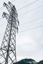 High voltage overhead power line, power pylon, steel lattice tower standing in the Alps mountains and solar park Royalty Free Stock Photo