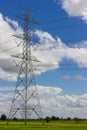 High voltage pole with green fields. Royalty Free Stock Photo