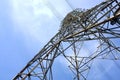 low angle view of steel framework of high voltage tower pole with electricity transmission power lines